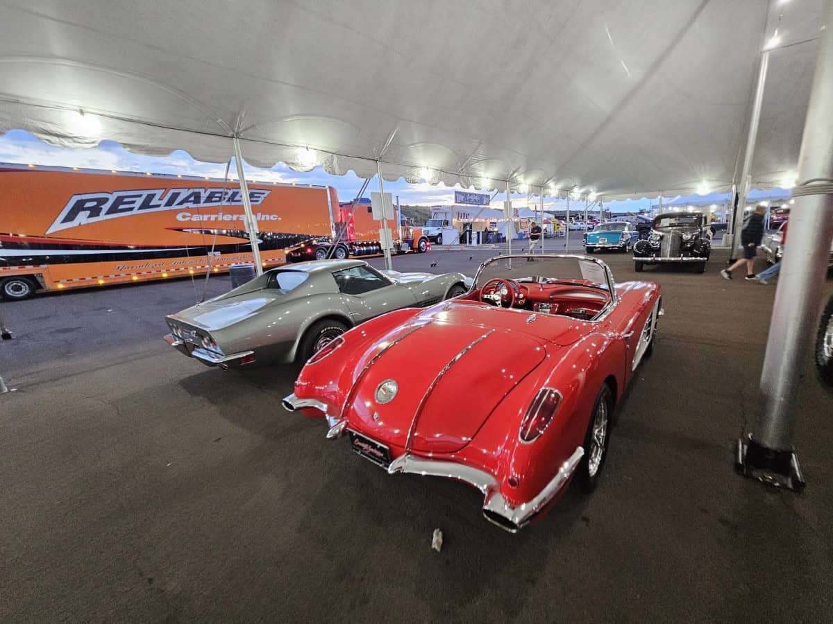 Vintage red and silver sports cars showcased at classic car event.